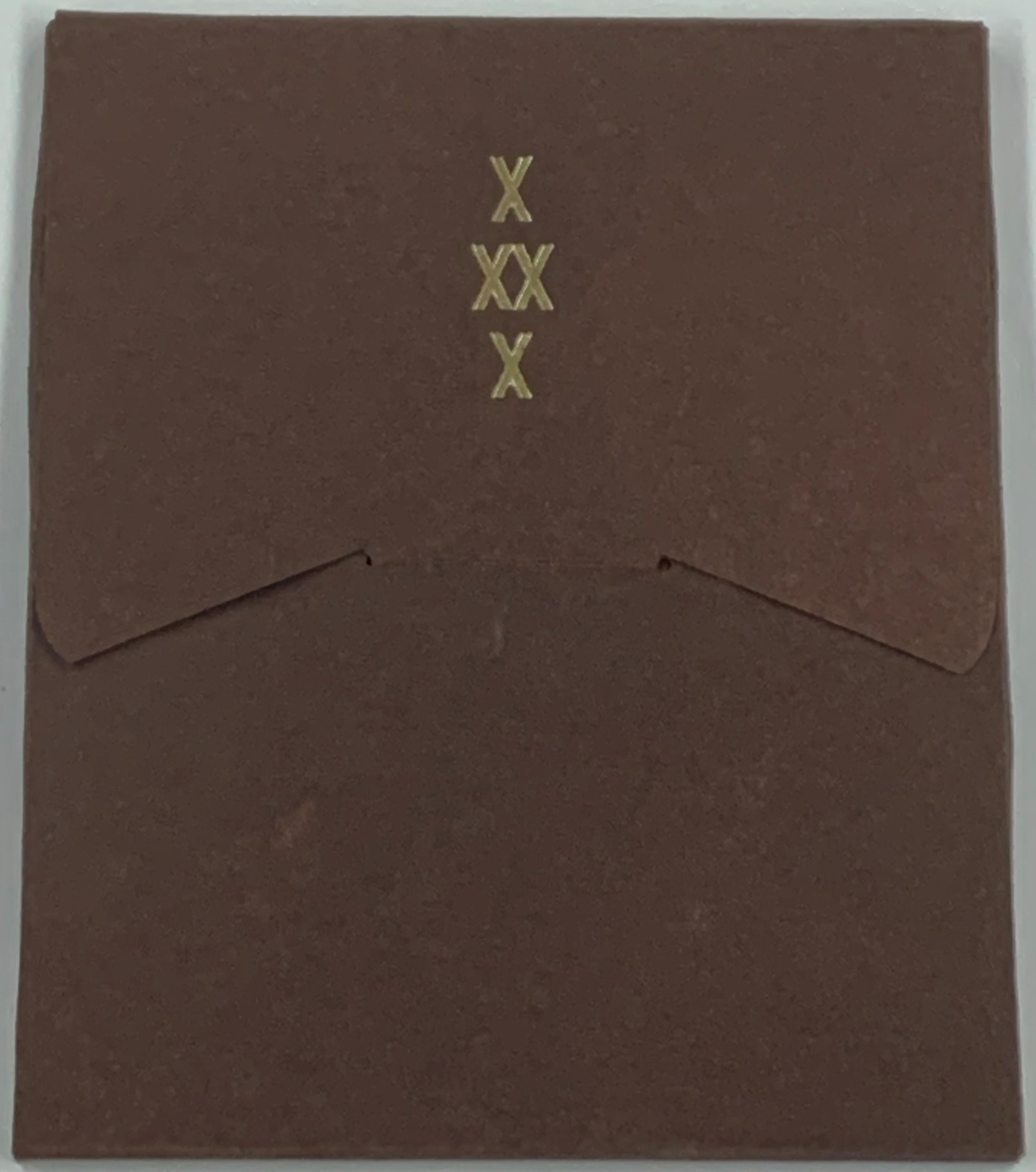 brown back cover of a wrapped enclosure with one flap inserted into the other in the middle and "X XX X" printed in the upper middle of the top flap