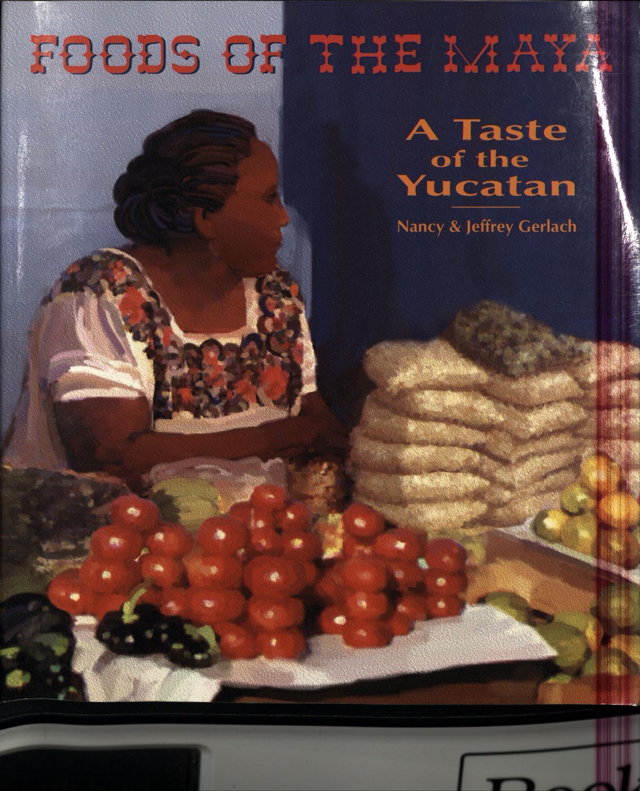 Book cover with an illustration of a Maya feminine figure behind a table of food; text reads: Foods of the Maya: a Taste of the Yucatan; Nancy & Jeffrey Gerlach