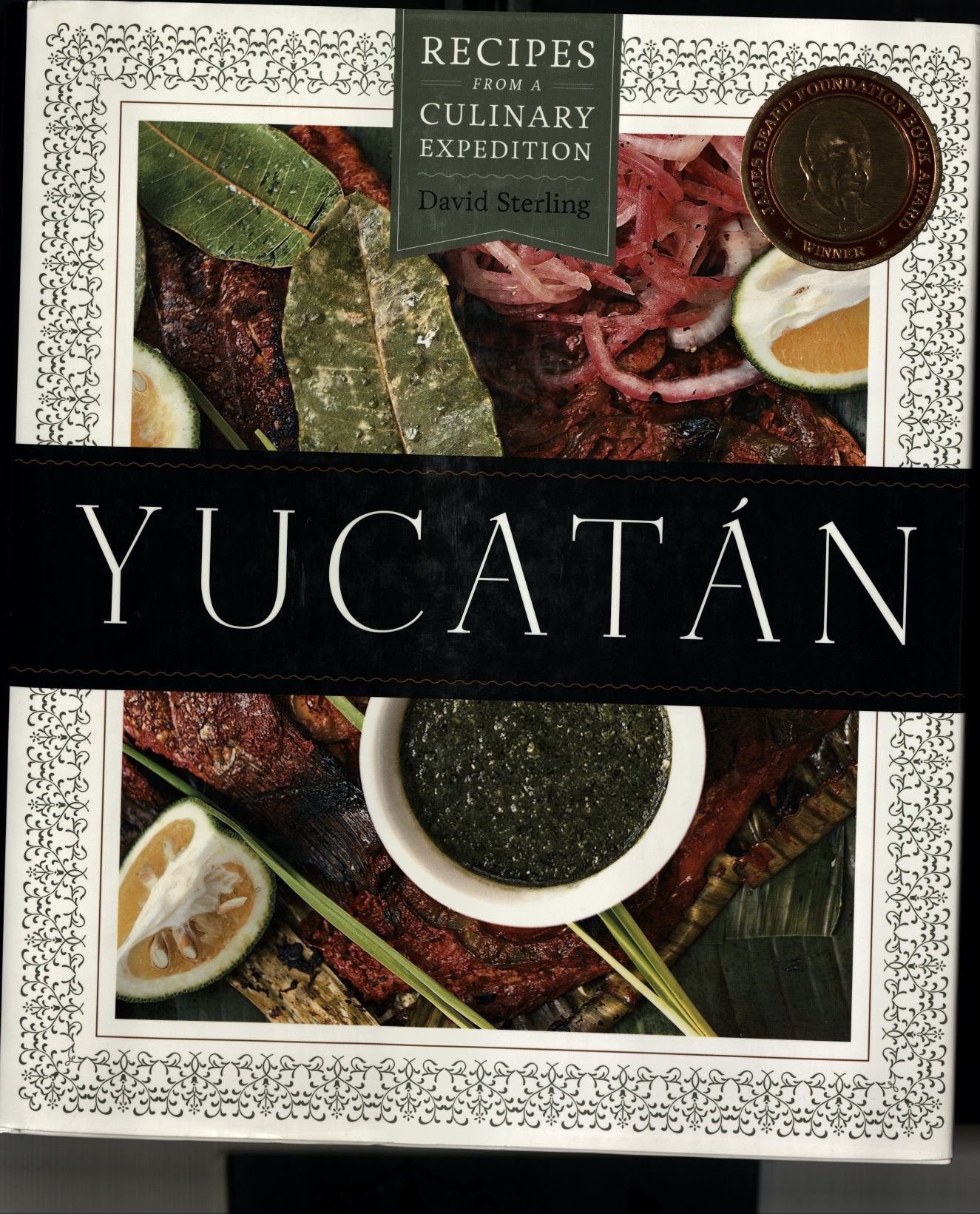 Book cover illustrated with a large spread of food; text reads: Recipes from a Culinary Expedition: David Sterling: Yucatán